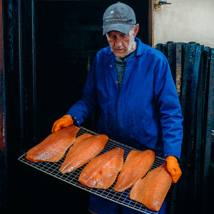 Ullapool Smokehouse Ian Boyd removing the smoked salmon from smoker. 